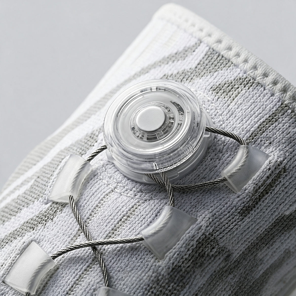 Macro of the transparent fit dial and cable lacing on the knitted sleeve